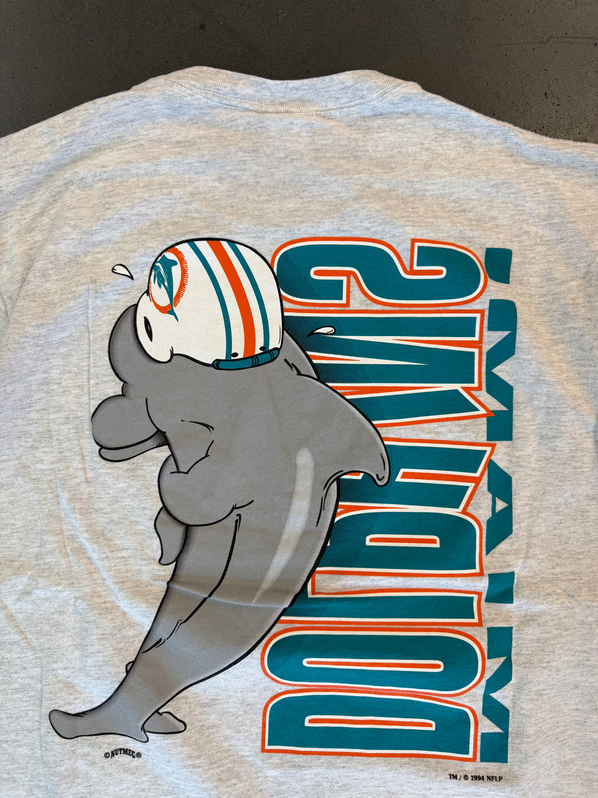 1994 MIAMI DOLPHINS VERTICAL SPELL-OUT ANIMATED DOLPHIN TEE (NUTMEG TAG)