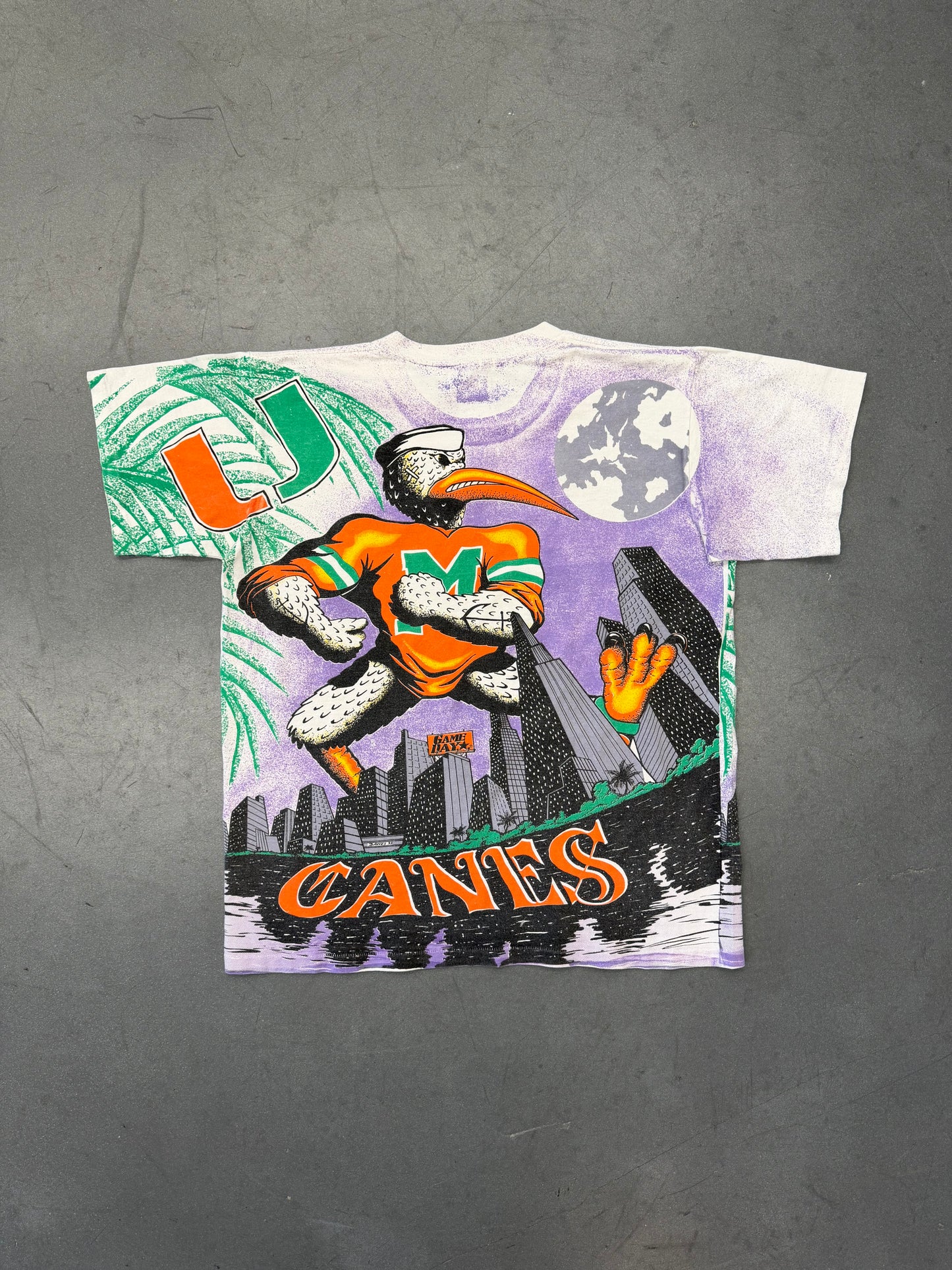 90'S UNIVERSITY OF MIAMI CANES PURPLE CITY SKYLINE GAME DAY AOP TEE (PULLED TAG) (REPAIRED NECK)