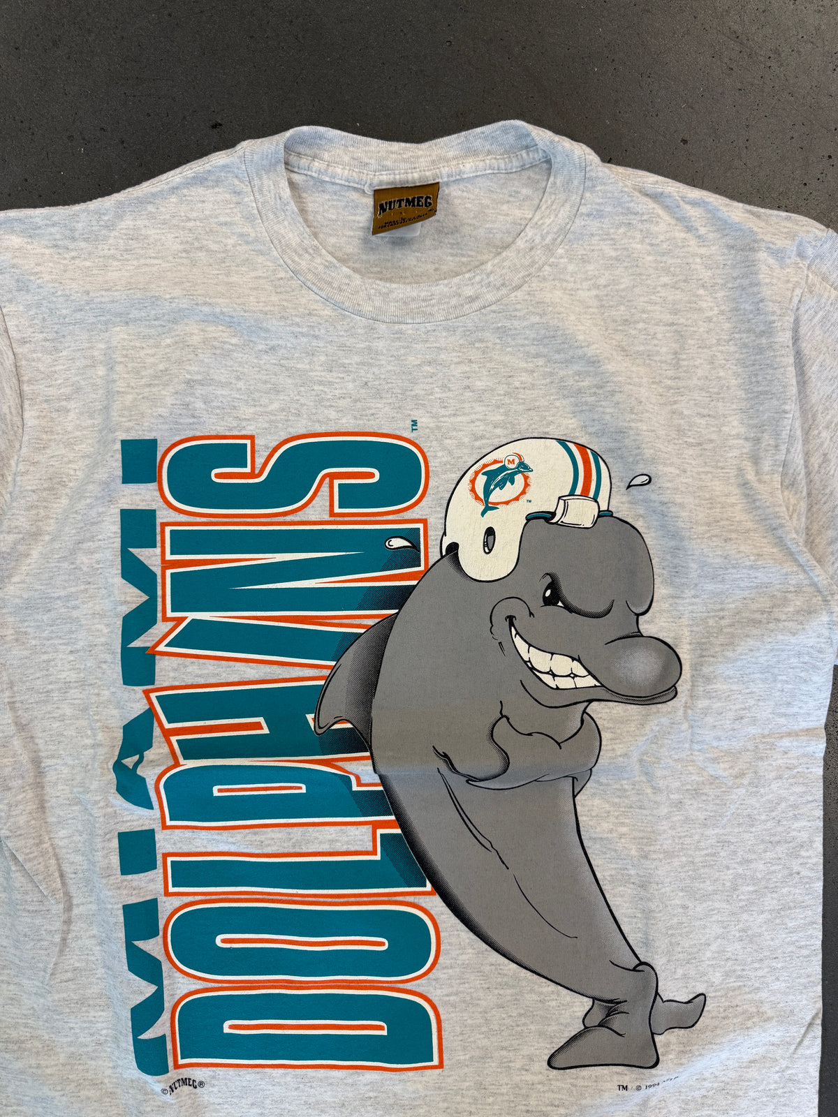 1994 MIAMI DOLPHINS VERTICAL SPELL-OUT ANIMATED DOLPHIN TEE (NUTMEG TAG)