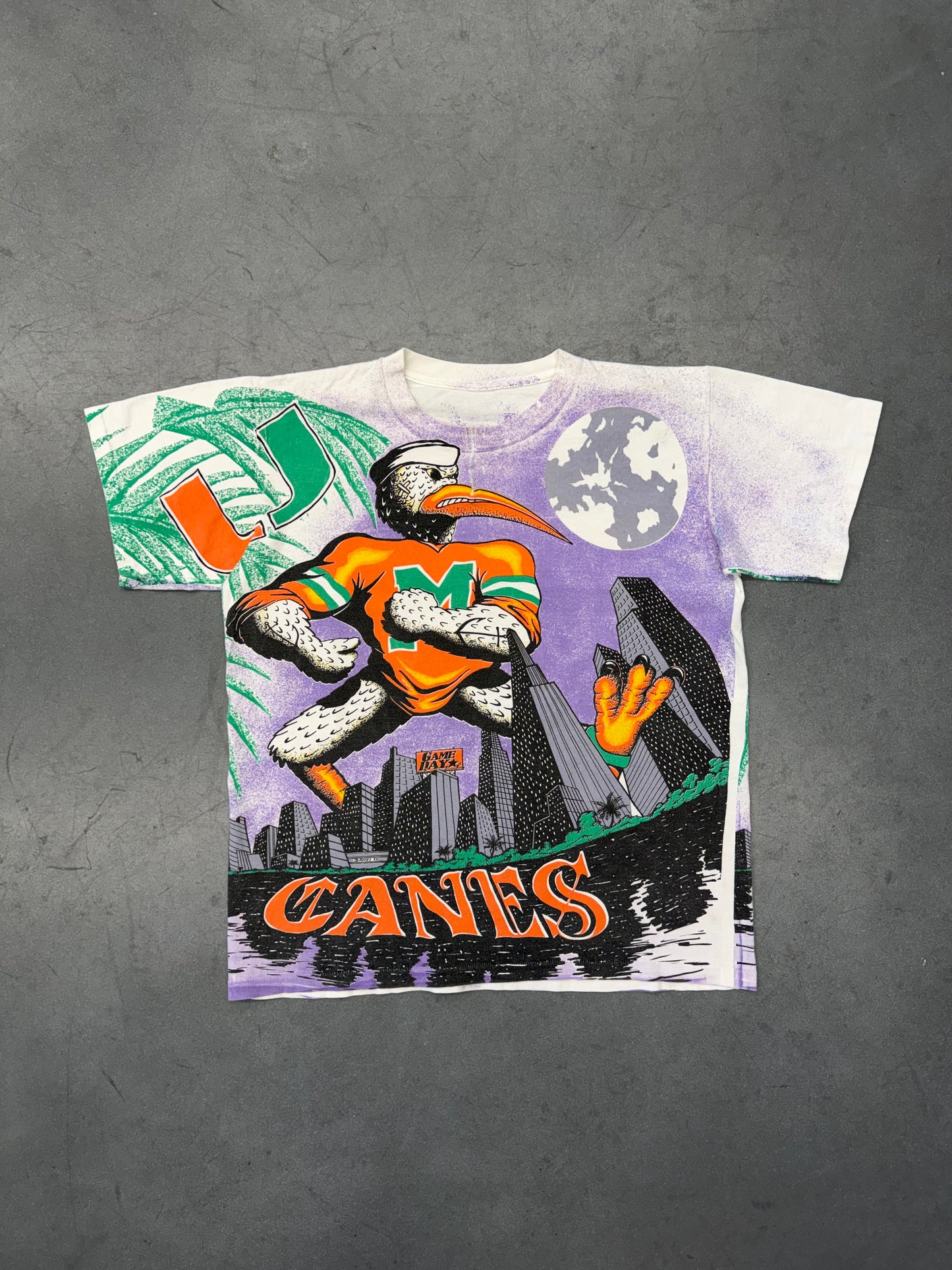 90'S UNIVERSITY OF MIAMI CANES PURPLE CITY SKYLINE GAME DAY AOP TEE (PULLED TAG) (REPAIRED NECK)